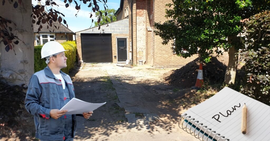 Construction professional reviewing plans at a driveway site next to a notepad with 'Plan' written on it, indicating the planning stage of driveway installation.